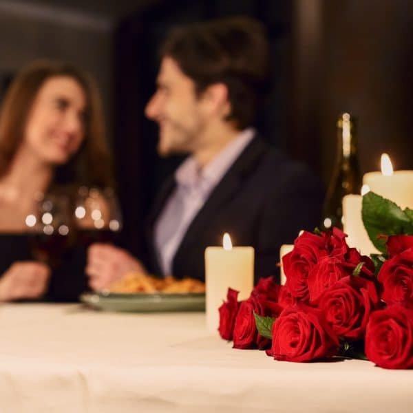 Bilde av et par som spiser en romantisk middag sammen. På bordet ligger røde roser. En seksuelt pirrende stemning i luften.